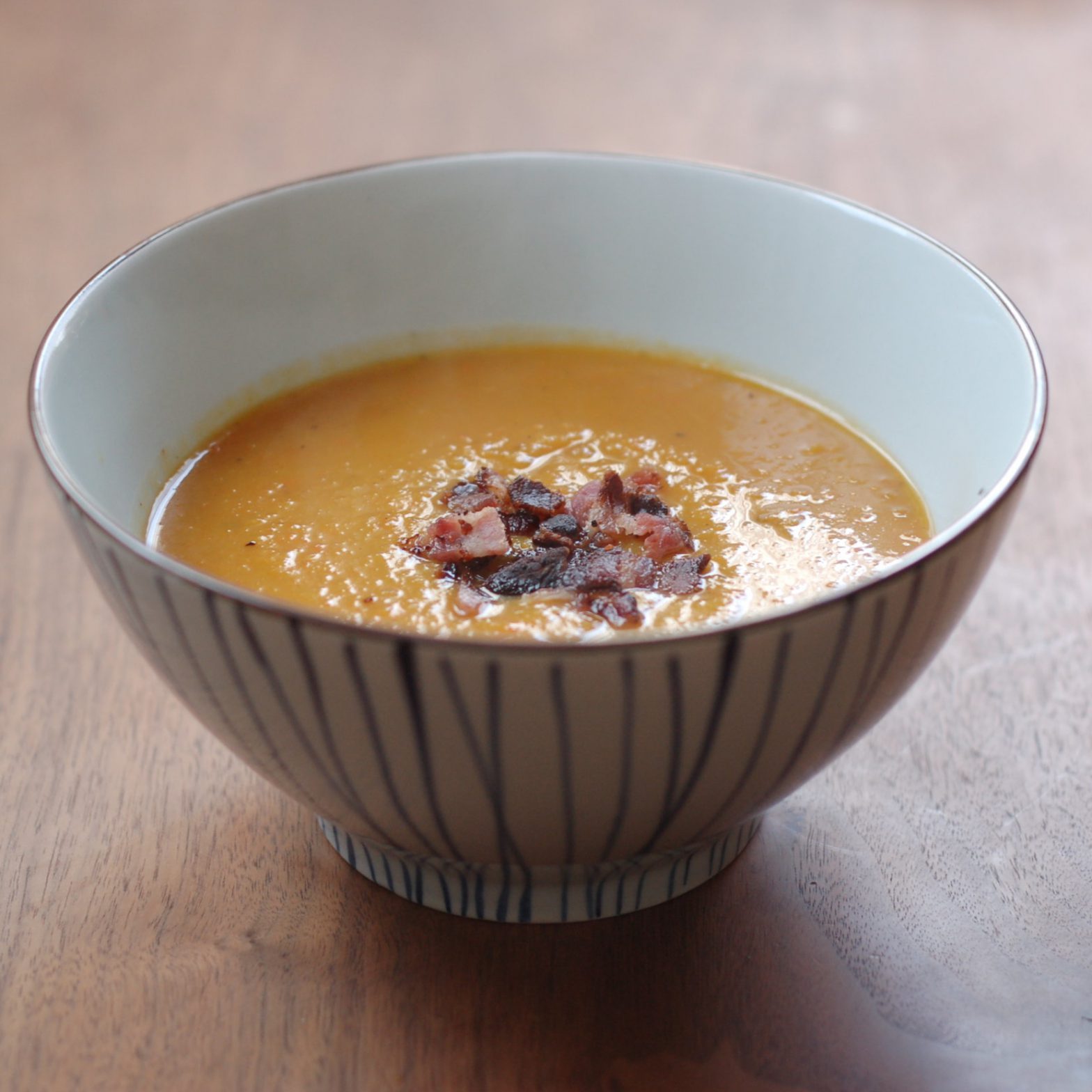 orange soup with bacon in the middle