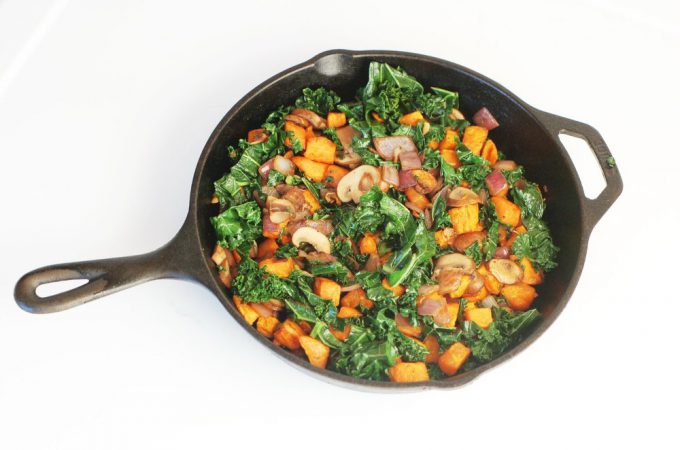 sweet potatoes, mushrooms and kale in a cast iron skillet