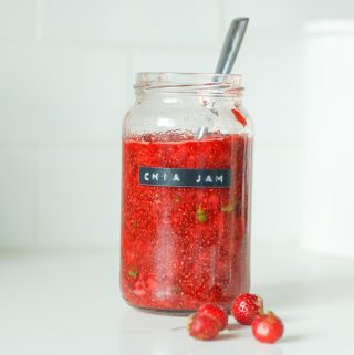 Red chia jam in a glass jar with a label