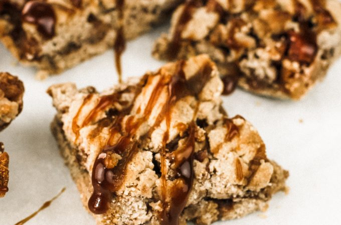 three apple pie bars side by side with salted caramel drizzle