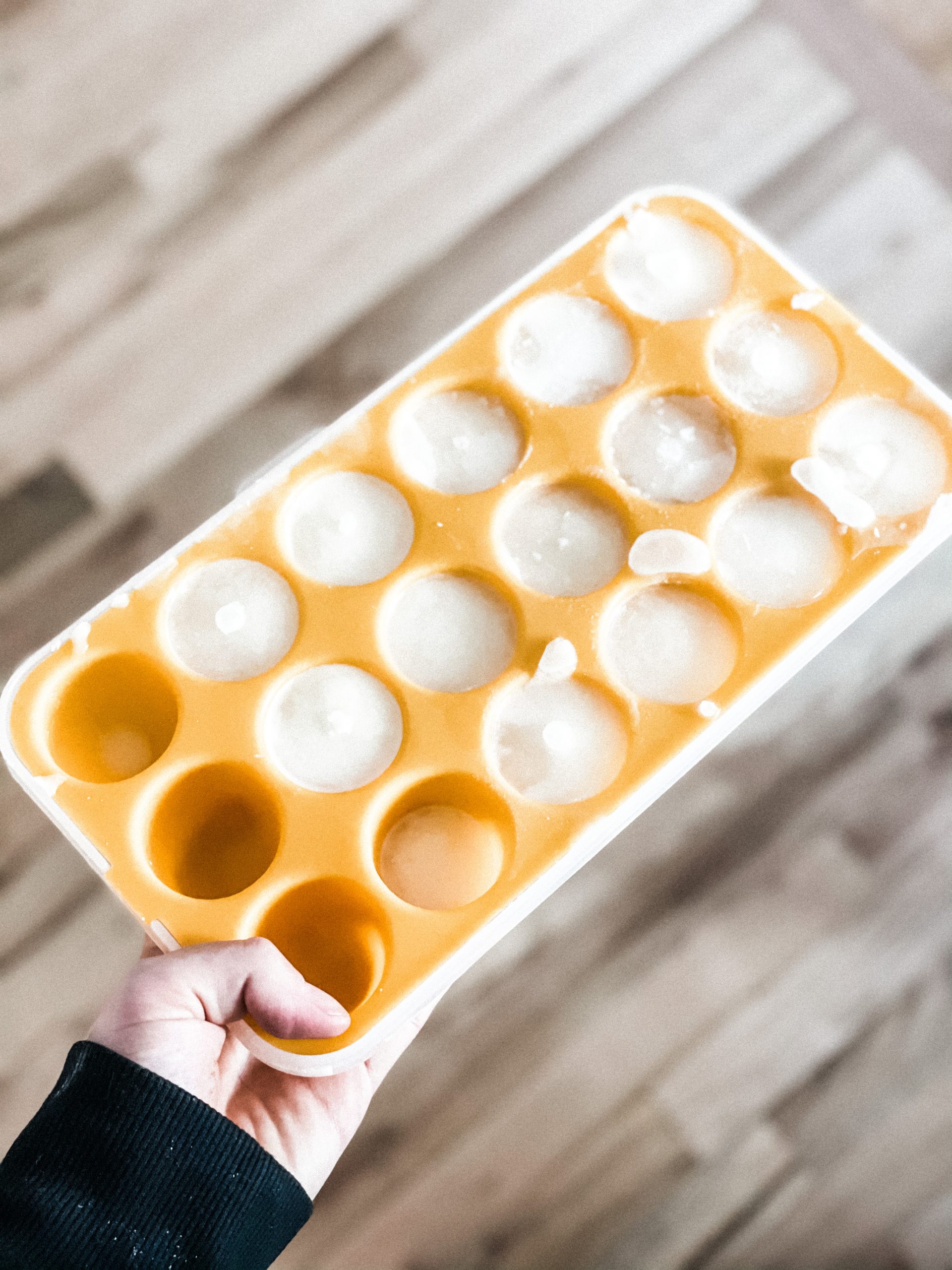 orange silicone ice cube tray with breast milk